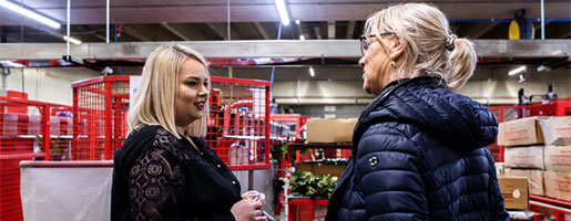 Twee vrouwelijke medewerkers in gesprek over agrarische uitzendkrachten.