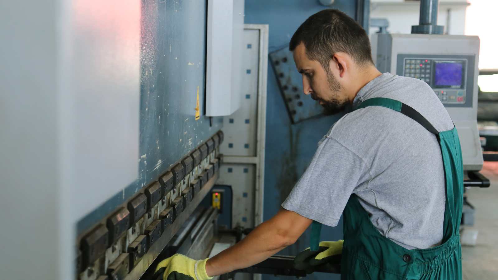 Magazijnmedewerker bedient een metaalmachine en verdient extra ploegentoeslag.