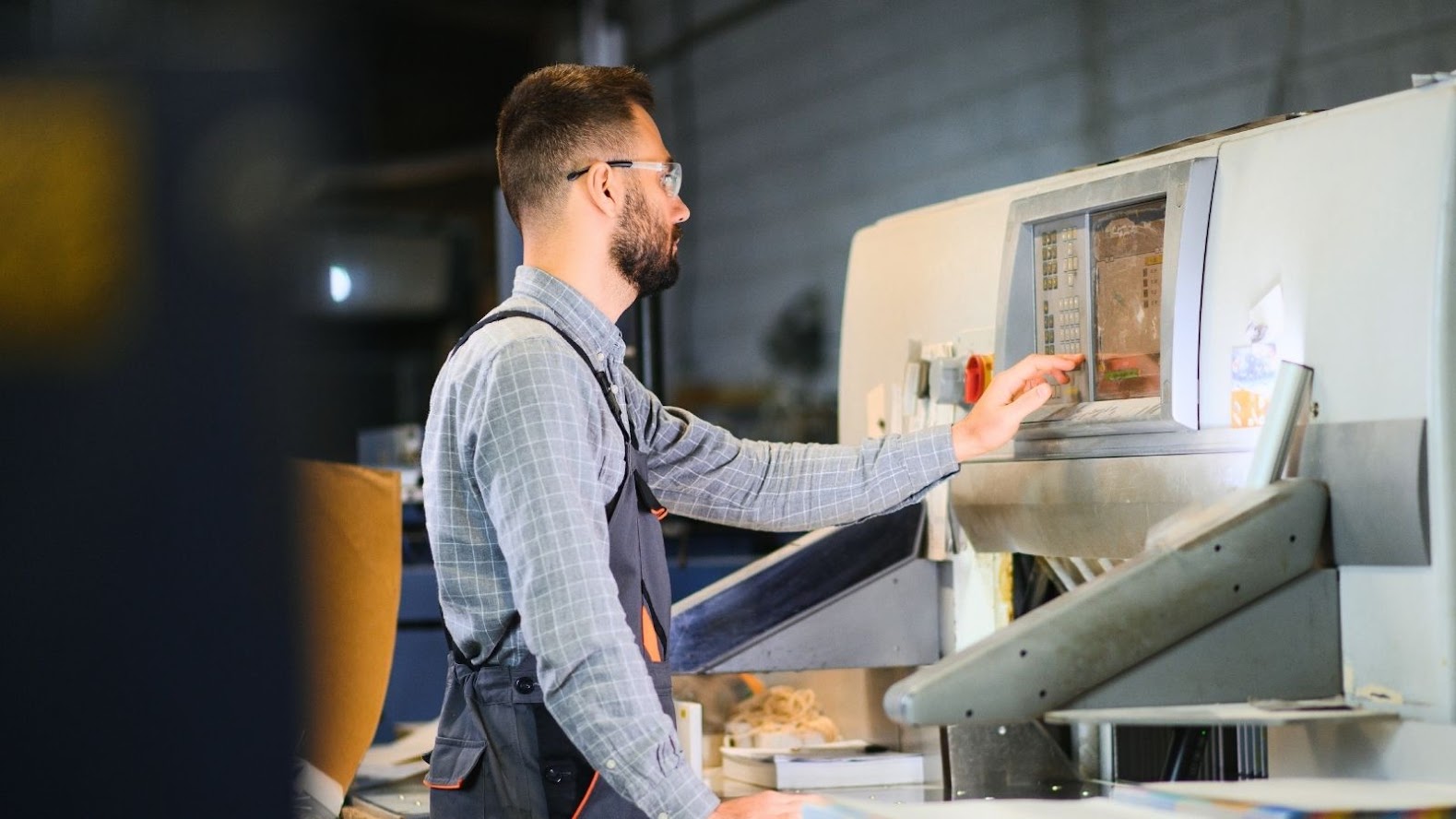 Productiemedewerker stelt een machine in op de werkvloer.